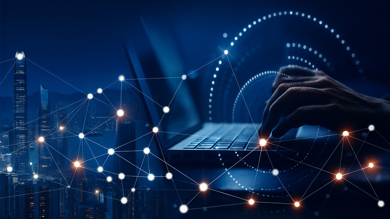 Mobile device shown in the foreground, with an abstract digital screen highlighting modern icons and interfaces, superimposed on a colored blurred background; the image communicates innovative digital solutions and smart technology.